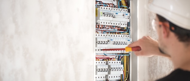 electrical-technician-working-switchboard-with-fuses_169016-5509
