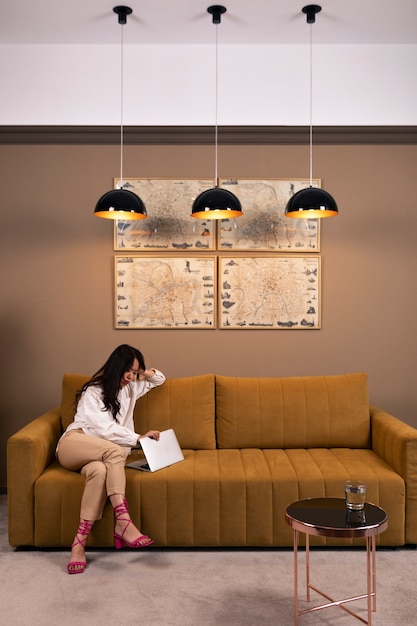 full-shot-woman-sitting-couch_23-2149729041