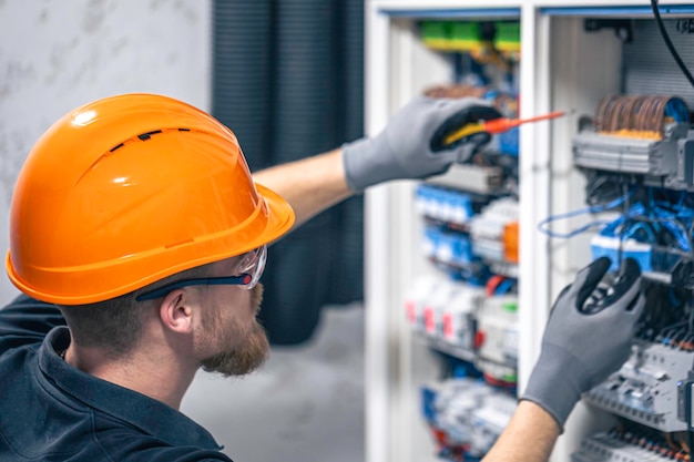 male-electrician-working-switchboard-with-fuses_169016-52227