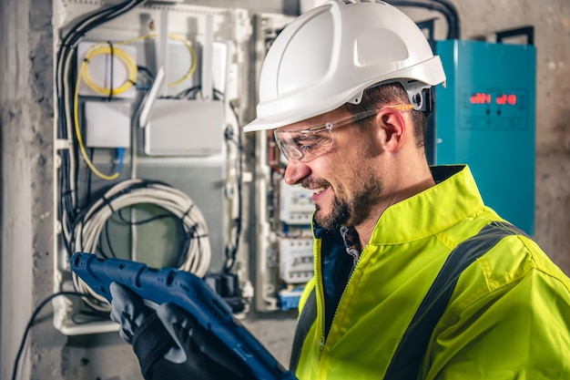 man-electrical-technician-working-switchboard-with-fuses-uses-tablet_169016-24593